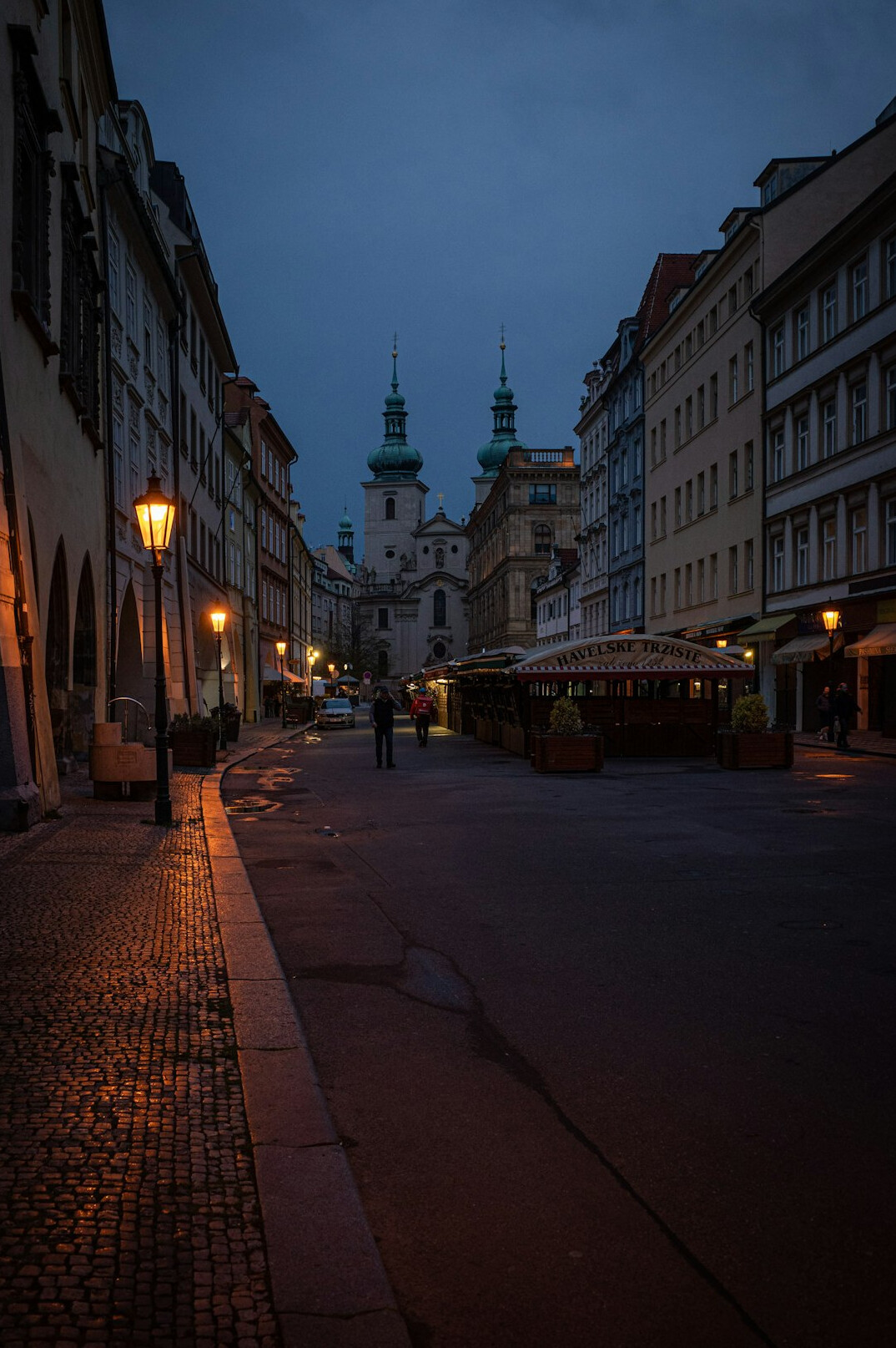 Quiet old city street at dusk with warm street lights